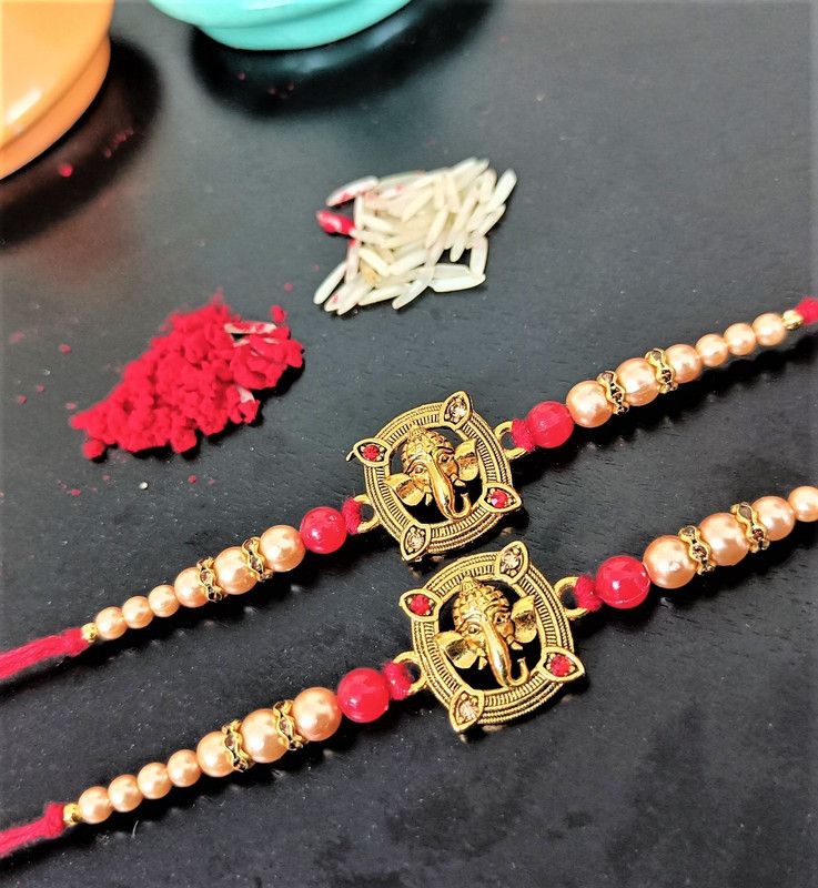 Rakhi, Chawal Roli Pack, Greeting Card Set  (Pack of 2 Ganesh Metal Rakhi for Brother Roli Chawal With Greeting Card)