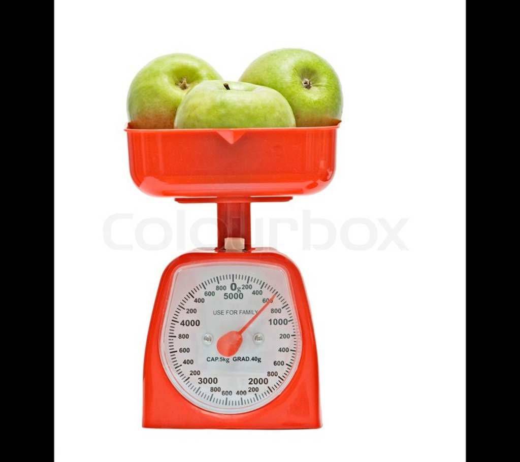 Red kitchen scale weighting nectarines