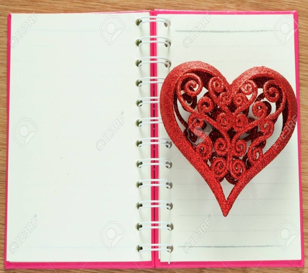 Valentines day background with red glitter heart on opened book for diary
